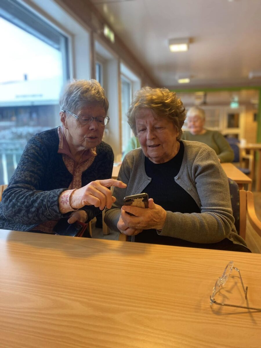 To eldre kvinner samarbeider om å lykkes å navigere i iphone.
